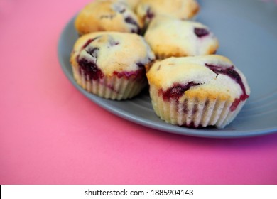 Five Muffins Made From Rice Flour, Yogurt And Cherries Lie On A Round Gray Plate On A Pink Background Side View.  Homemade Gluten Free Baked Goods