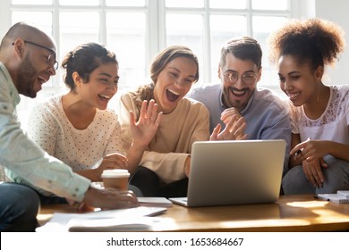 Five multi-ethnic millennial friends sitting on sofa looking at computer screen wave hands laughing enjoy distant communication with mate. Make videocall, greeting online by webcam modern tech concept - Shutterstock ID 1653684667