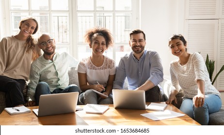 Five multi-ethnic students cheerful girls and guys sitting on couch laughing posing looking at camera, concept of multiracial friendship, studying process, common project, teamwork and racial equality - Shutterstock ID 1653684685