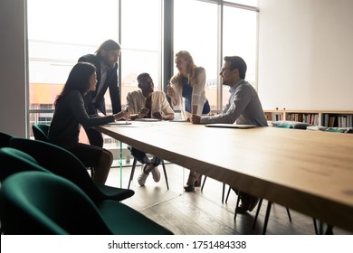 Five multinational workgroup creative team brainstorming thinking gathered in morning briefing group meeting in board room discuss ideas planning future projects solving problems together at workplace - Shutterstock ID 1751484338