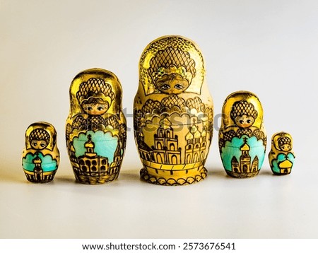 Five nesting dolls of different sizes, Russian wooden doll on a white background. Gold color with Orthodox domes.
