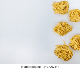 Five nests of fresh linguine pasta on a white background, perfect for Italian cuisine concepts and culinary imagery - Powered by Shutterstock