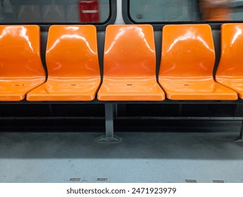 Five orange subway empty seats. Train seat. Rail public transportation system. No people, nobody. Horizontal photo. Metro. 