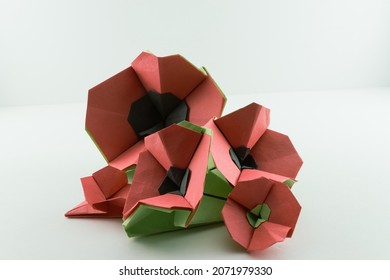 Five origami poppies arranged in a bunch ranging in sizes.