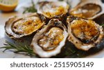 Five oysters with a yellow sauce on top. The sauce is made from butter and lemon juice. The oysters are arranged on a white plate with some herbs and lemon slices