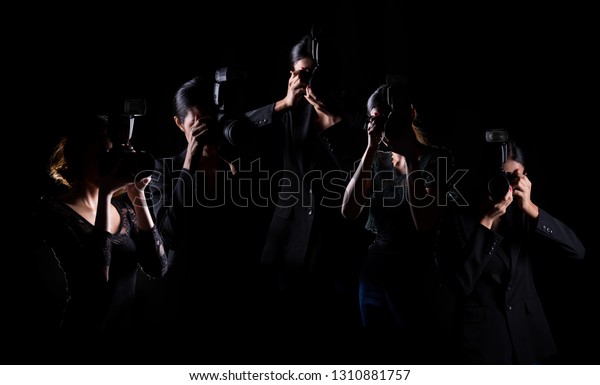 Five Photographers hold camera with external\
flash point to shoot front, wear normal black suit jacket. studio\
lighting dark background isolated low exposure, reporter journalist\
take photo celebrity