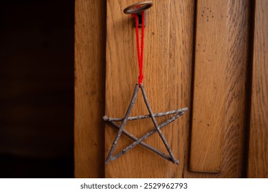 Five pointed star made from twigs, tied at points, red string attached, rustic decoration, festive ornament, natural design, hanging decoration, holiday decor, DIY, wooden background - Powered by Shutterstock