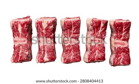Five raw beef short rib pieces with visible bone and marbled red meat