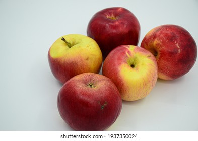 five ripe red and yellow apples on a white background