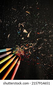 Five Sharperned Colored Pencils That Scattered Randomly On Black Paper Taken From Above High Angle