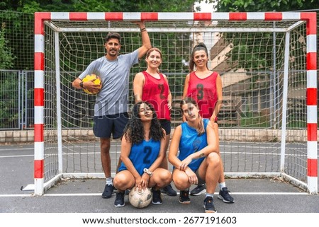 Five a side soccer team posing confidently with soccer balls in front of the goal, embodying teamwork and sportsmanship while preparing for a friendly match on the field