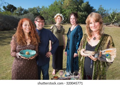 Five Smiling Wicca Practitioners Standing Outdoors With Smudge Stick