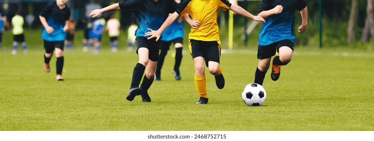 Five soccer players run toward soccer goal and kick the ball. Young football players in league match. European football players' legs in action. Soccer forward in tough competition with defenders - Powered by Shutterstock