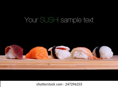 Five species of fish sushi on bamboo board, text space