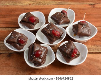 Five star chocolate flavored betel leaf on ice stuffed with cherry known as Five star chocolate paan. A widely loved mouth-freshener cum dessert recipe with selective focus on white plate