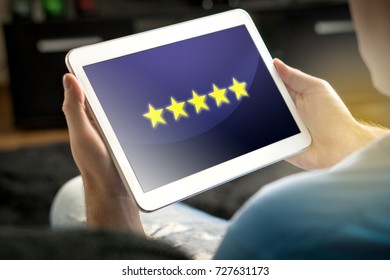 Five Star Rating And Review From Satisfied And Happy Customer And Reviewer. Man Holding Tablet With An Imaginary Criticism Application, Social Media Or Website On Screen. 