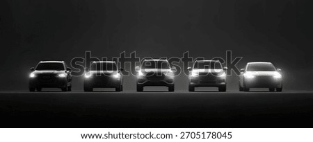 Five SUVs lined up with headlights on, dark background