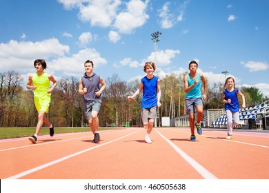 Five Teenage Sprinters Running Together On A Track