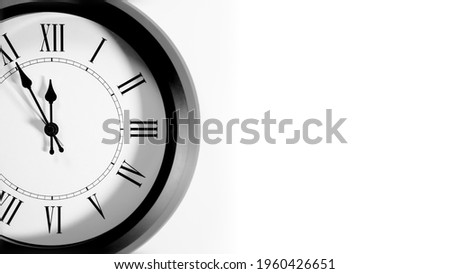 It is five to twelve, the clock is ticking. Grey Watch shows the time 5 before 12. Close up to a wall clock, with five minutes to twelve o'clock. Time is running out. White background with copy space