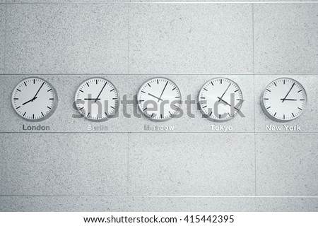 Five wall clocks showing time in different capitals of the world.
