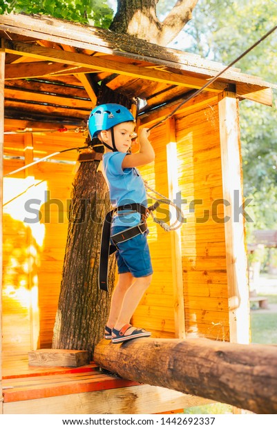 Five year boy on rope-way\
in forest