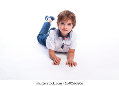 A five year old boy. A cute five year old boy studio portrait on white background. A boy with very big nice eyes. A boy wearing jeans and white T-shirt. 