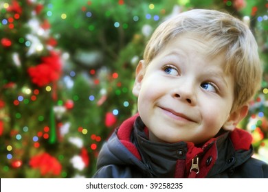 Five Year Old Boy Portrait Outside With Decorated Christmas Trees