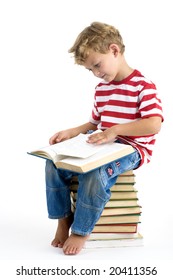 Five Year Old Boy Sitting On Pile Of Books, Reading