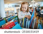 Five year old girl selecting a book in municipal library