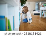 Five year old girl selecting a book in municipal library