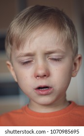 Five years old boy with allergy runny nose and closed eyes. 