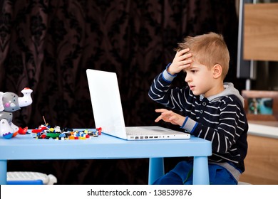 A Five Years Old Child Looking At His Laptop At Home, Kid Playing At Laptop In The Living Room, Making A Mistake, Failure, Losing