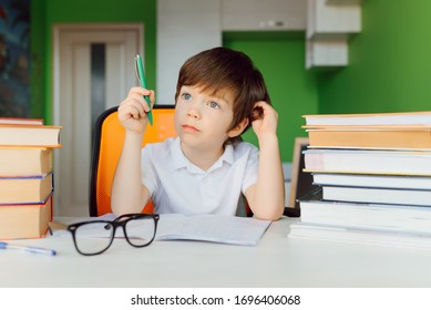 Five Years Old Child Reading A Book At Home. Boy Studying At Table On Green Background