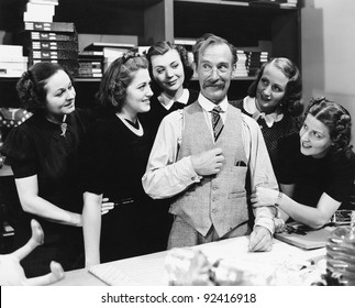 Five young women gathering around a salesman in a store - Shutterstock ID 92416918