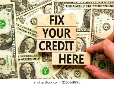 Fix your credit here symbol. Concept words Fix your credit here on wooden blocks on a beautiful background from dollar bills. Businessman hand. Business, finacial and fix your credit here concept.