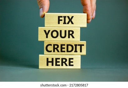 Fix your credit here symbol. Concept words Fix your credit here on wooden blocks on a beautiful grey table grey background. Businessman hand. Business, finacial and fix your credit here concept.