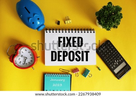 Fixed deposit investment concept on open notepad with different stationery. 