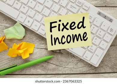 FIXED INCOME on white keyboard stickers.glasses notepad on wooden background. - Shutterstock ID 2367063325