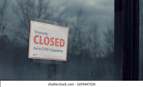 FIXED View Of A Temporary Closed Due COVID-19 Pandemic Sign Hanging On A Window. Coronavirus Pandemic, Small Business Shutdown