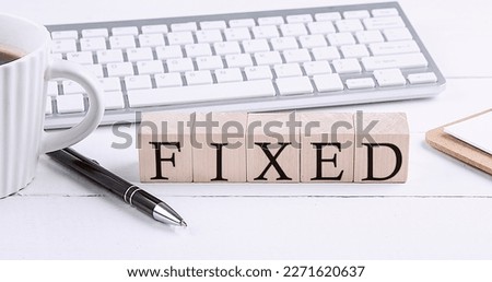 FIXED word on wooden blocks with keyboard and coffee