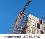 A fixed-position building tower system installed at an under-construction site plays a central role in the development of modern infrastructure projects. Designed to remain anchored in one location for the duration of a major phase of construction, this type of lifting structure provides exceptional power, extended reach, and precise load control. It is a highly engineered system built to handle the demanding requirements of large-scale building operations, including high-rise structures, bridges, commercial complexes, and industrial facilities.
At the core of the tower crane’s design is its vertical mast, which is securely fixed to a reinforced concrete foundation. This stable base ensures the crane can safely lift and transport heavy materials to significant heights without compromising structural integrity. The mast is assembled in sections and can be extended as the building rises, allowing the structure to grow along with the project. This adaptability makes it an essential asset in developments where elevation increases progressively over time.
The horizontal jib extends outward from the top of the mast, forming the working arm that carries materials across the site. Depending on the model and configuration, the crane can rotate 360 degrees, providing full coverage of the surrounding construction area. Its impressive reach allows it to access multiple zones without repositioning. This efficient coverage significantly reduces downtime and improves workflow coordination among construction teams.
One of the most critical features of a fixed tower crane is its lifting capacity. Engineered with high-tensile steel components and advanced load management systems, the equipment can hoist heavy construction materials such as structural steel beams, precast concrete panels, reinforcement cages, mechanical equipment, and prefabricated sections to elevated positions with accuracy and stability.