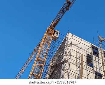 A fixed-position building tower system installed at an under-construction site plays a central role in the development of modern infrastructure projects. Designed to remain anchored in one location for the duration of a major phase of construction, this type of lifting structure provides exceptional power, extended reach, and precise load control. It is a highly engineered system built to handle the demanding requirements of large-scale building operations, including high-rise structures, bridges, commercial complexes, and industrial facilities.
At the core of the tower crane’s design is its vertical mast, which is securely fixed to a reinforced concrete foundation. This stable base ensures the crane can safely lift and transport heavy materials to significant heights without compromising structural integrity. The mast is assembled in sections and can be extended as the building rises, allowing the structure to grow along with the project. This adaptability makes it an essential asset in developments where elevation increases progressively over time.
The horizontal jib extends outward from the top of the mast, forming the working arm that carries materials across the site. Depending on the model and configuration, the crane can rotate 360 degrees, providing full coverage of the surrounding construction area. Its impressive reach allows it to access multiple zones without repositioning. This efficient coverage significantly reduces downtime and improves workflow coordination among construction teams.
One of the most critical features of a fixed tower crane is its lifting capacity. Engineered with high-tensile steel components and advanced load management systems, the equipment can hoist heavy construction materials such as structural steel beams, precast concrete panels, reinforcement cages, mechanical equipment, and prefabricated sections to elevated positions with accuracy and stability.