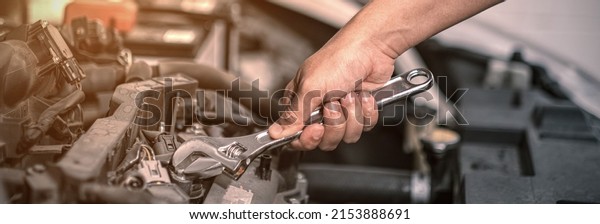 Fixing automotive engine, car service and\
maintenance, Repair service, repairman hands repairing a car engine\
automotive workshop with a wrench, Auto service,  maintenance\
concept, Fix car.