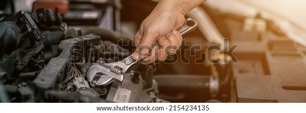 Fixing automotive engine, car service and\
maintenance, Repair service, repairman hands repairing a car engine\
automotive workshop with a wrench, Auto service,  maintenance\
concept, Fix car.