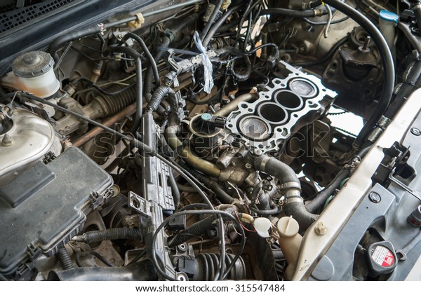 Fixing car engine using local method and\
simply tools found in local part of\
Thailand