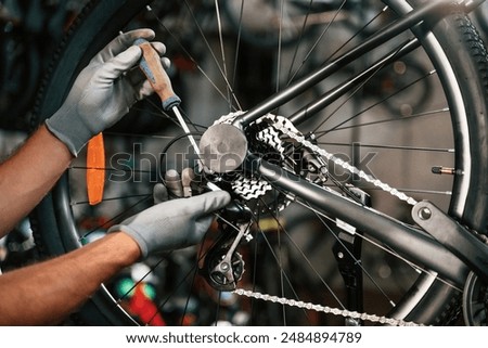 Fixing the derailleur. Close up view of man's hands that is repairing bicycle.