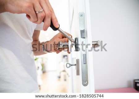 Fixing, repairing door handle with a screwdriver.