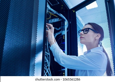 Fixing wires. Determined smart woman working in a service cabinet and repairing wires