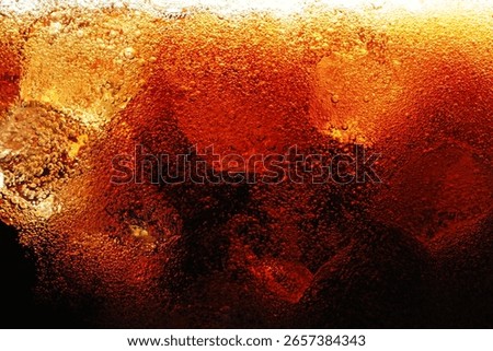 Fizzy cola with ice as background, macro view