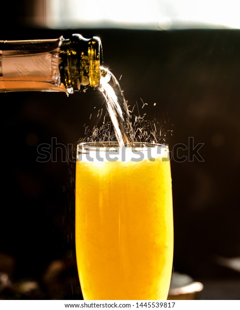 Fizzy\
pouring close up of champagne mimosa\
cocktail